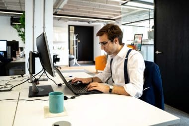 In-House Legal Solutions team member working at a laptop in the office.